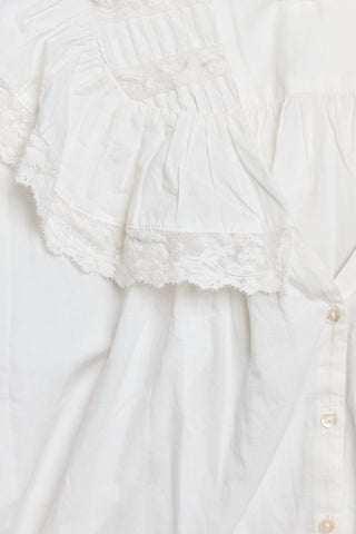 White blouse with lace detailing on a light gray background