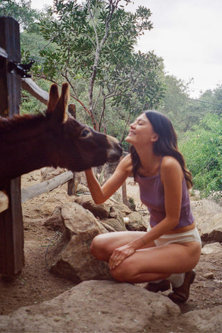 Woman interacting with a donkey in a natural setting
