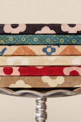 Stack of colorful fabric strips on a decorative stand with a neutral background