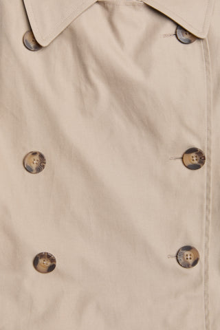 Close-up of a beige trench coat with buttons