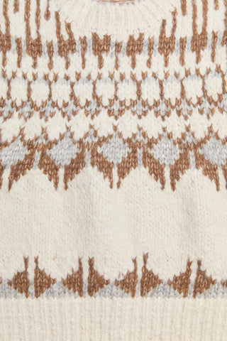 Close-up of a textured fabric with a pattern of brown and white shapes.