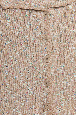 Close-up of a textured fabric with buttons on a beige background