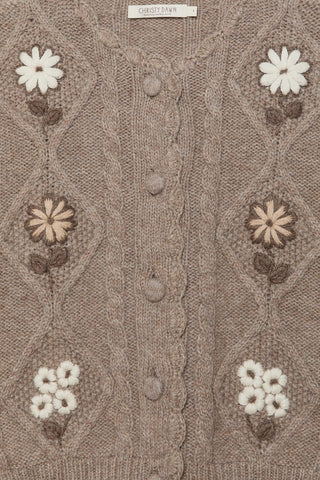 Close-up of a brown knitted cardigan with floral patterns and buttons.