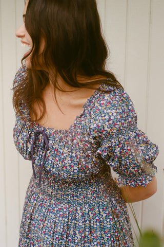 Woman wearing a floral dress with a neutral background