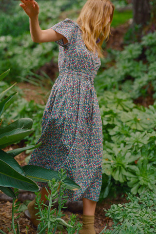 Woman in a floral dress standing in a garden