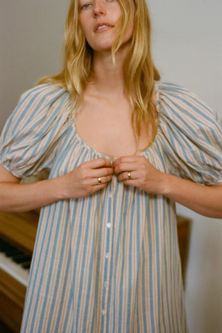 Woman wearing a striped dress with a neutral background