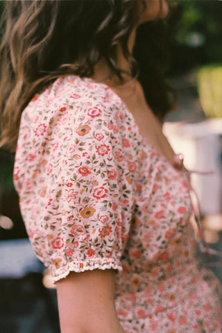 Person wearing a floral dress with a blurred background