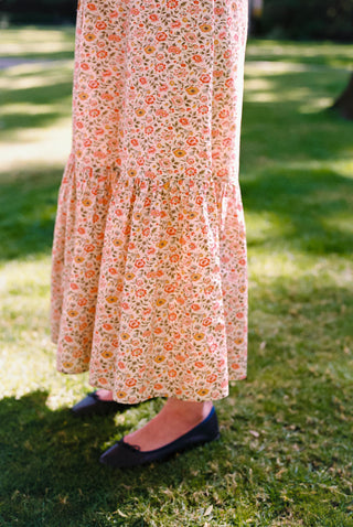 Person wearing a floral dress standing on grass