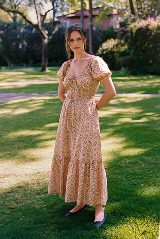 Woman in a floral dress standing in a garden