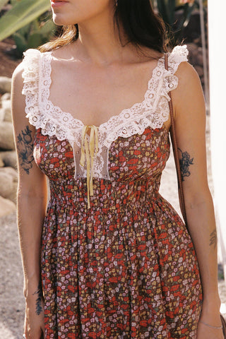 Woman wearing a floral dress with lace details in an outdoor setting