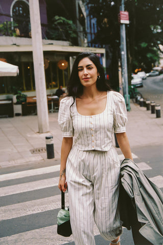Woman in a striped outfit standing on a city street