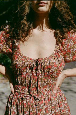Woman wearing a red floral dress with a blurred background