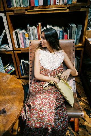 Woman sitting in a chair holding a book in a library setting