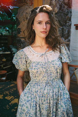 Woman wearing a floral dress in an indoor setting