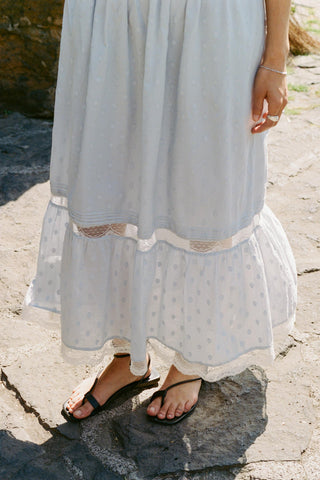 Light blue dress with lace details on a stone surface