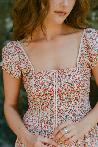 Woman wearing a floral dress with a blurred natural background