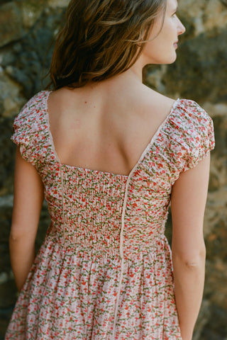 Woman wearing a floral dress with a blurred natural background