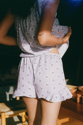 Person wearing a matching top and shorts set with a floral pattern in a casual setting.