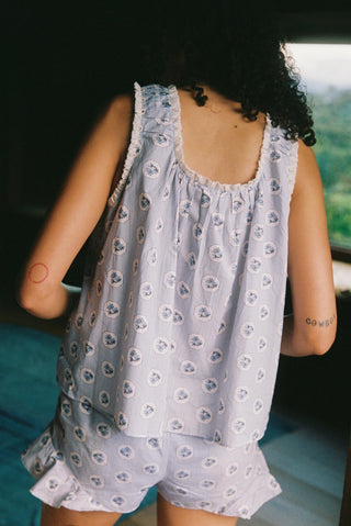 Person wearing a light blue floral set with a blurred background