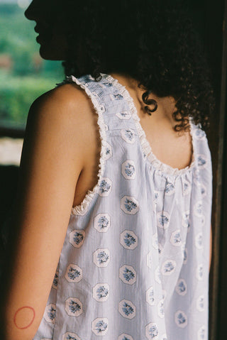 Person wearing a light blue floral dress with a blurred background