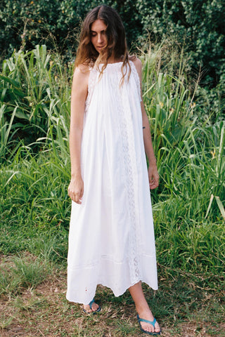 Woman in a white dress standing in a grassy field