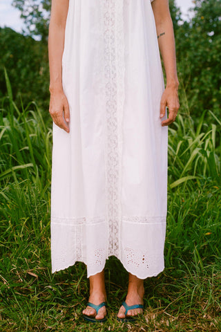 Person wearing a white lace dress standing in a grassy field