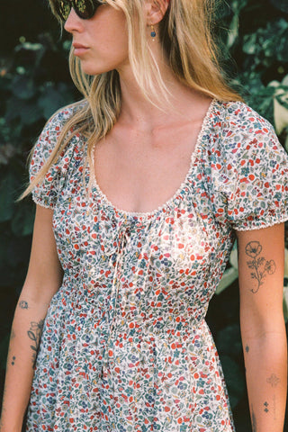 Woman wearing a floral dress with a blurred natural background