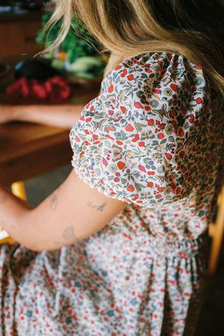 Person wearing a floral dress with a blurred background
