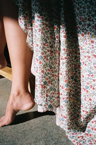 Close-up of a person wearing a floral dress with a blurred background