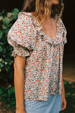 Woman wearing a floral blouse with a blurred background