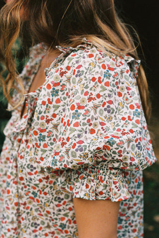 Person wearing a floral dress with a blurred background