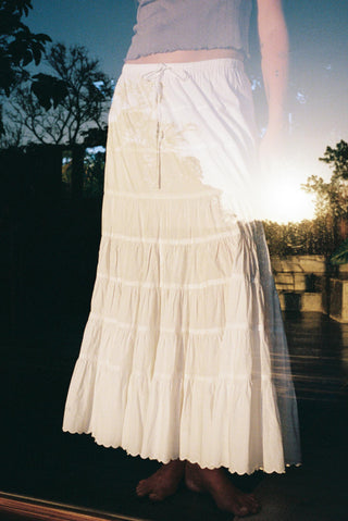 Person wearing a white skirt with a blurred background