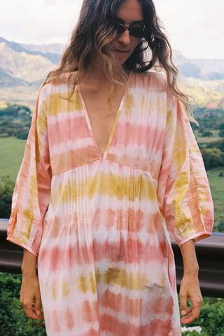 Woman wearing a tie-dye dress with a scenic background