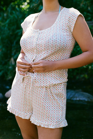 Woman wearing a floral patterned matching set with a blurred green background