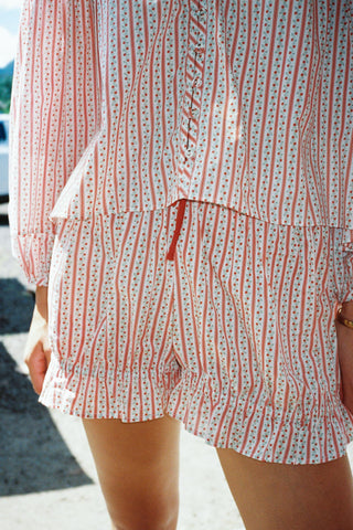 Red and white striped shorts with a subtle pattern worn by a person.