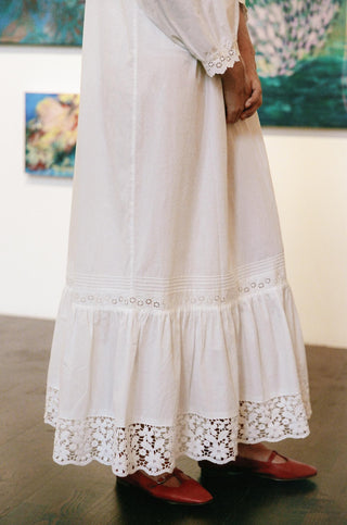 White lace dress with red shoes in an indoor setting