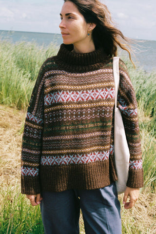 Woman wearing a patterned oversized sweater in a field 