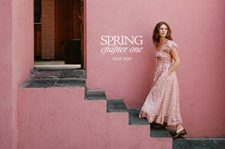 Woman in a floral dress standing on pink steps with 'Spring chapter one' text.