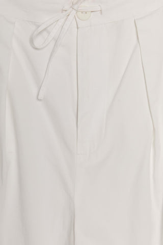 Close-up of white pants with a tie detail