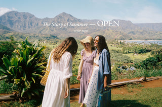 Three women standing in a scenic outdoor setting with mountains and a lake in the background, promoting 'Summer Chapter I - OPEN'.