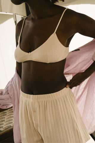 Woman wearing a beige bra and pants with a blurred background