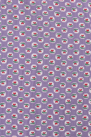 Patterned fabric with red and green shapes on a purple background