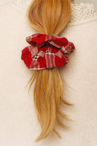 Red plaid scrunchie on a ponytail against a beige background