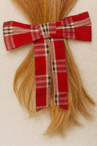 Plaid bow with hair extensions on a neutral background