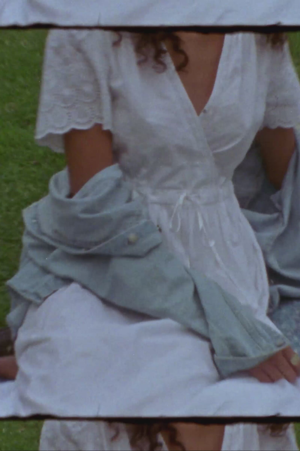 Woman in a white dress sitting and standing in a park with a ru