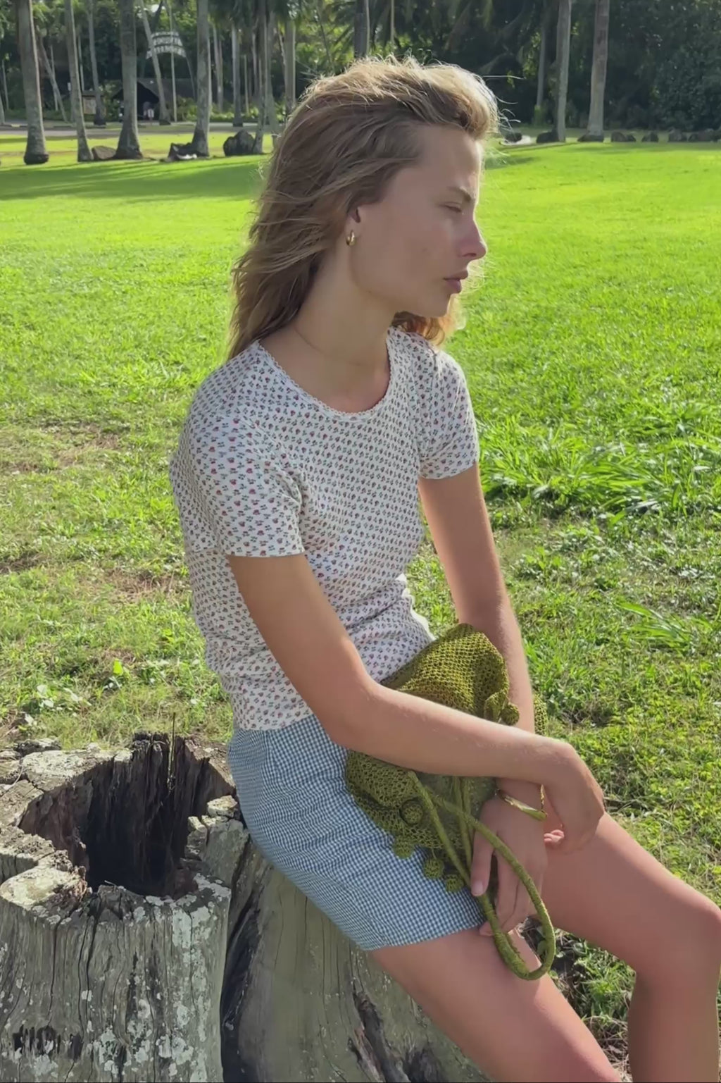Close up video of a white top with red and blue floral print, worn by a woman