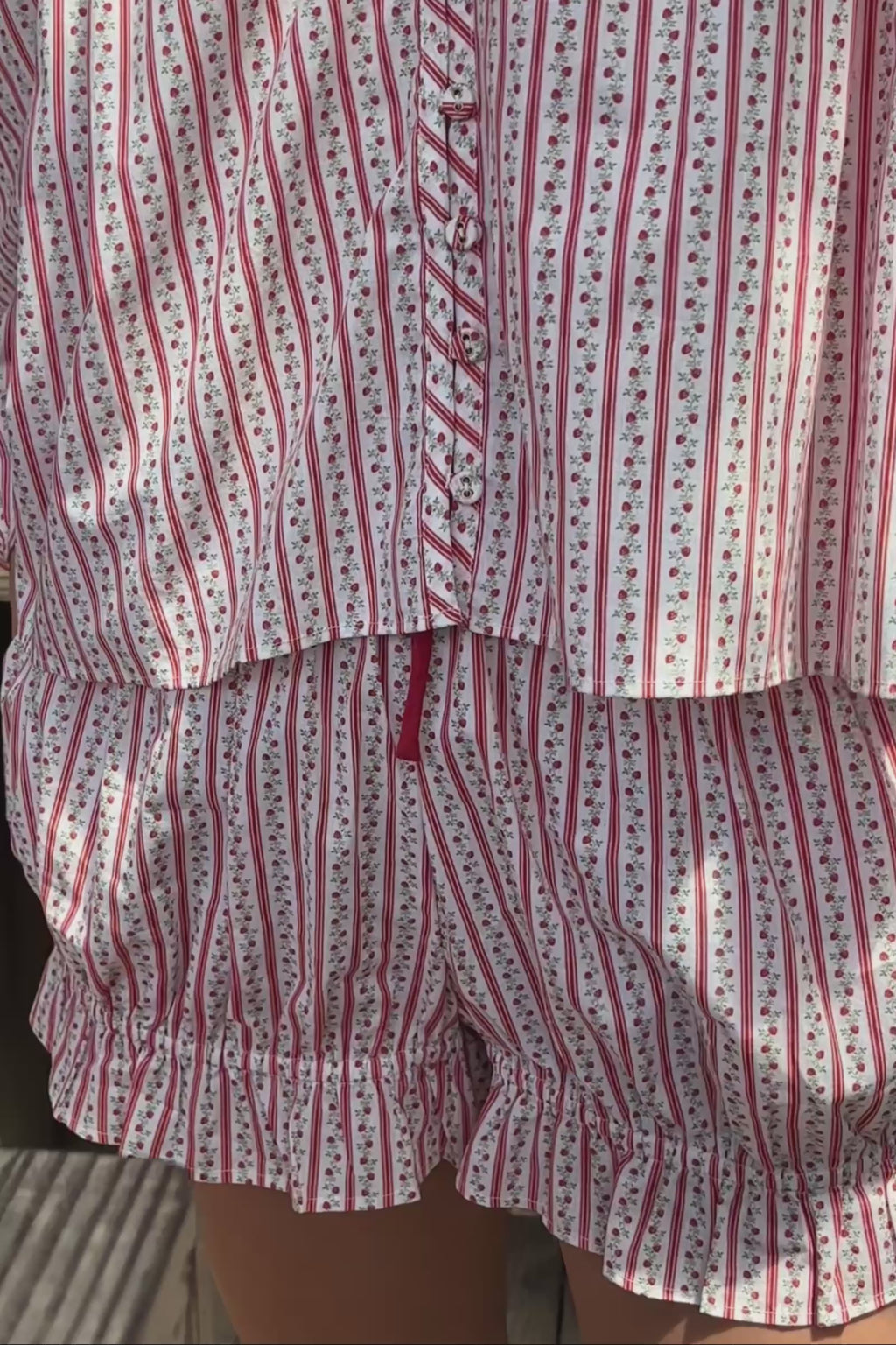 Video close up of a woman wearing a red and white striped matching top and blouse. 