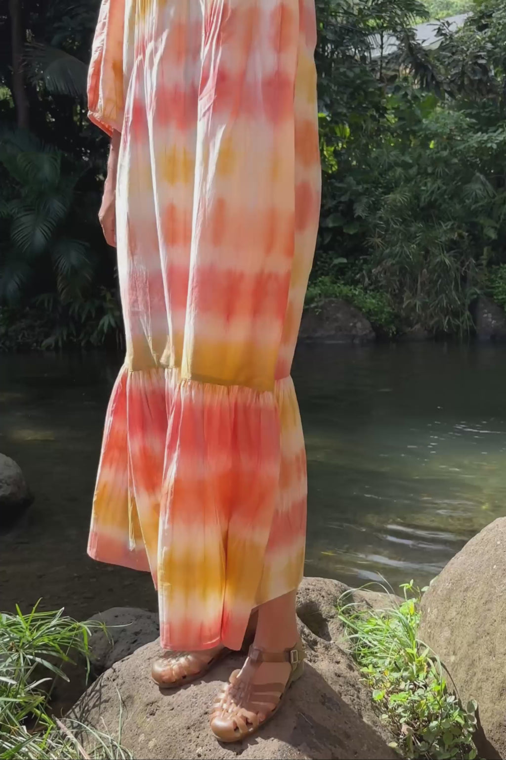 Video close up of a tie-dyed dress, followed by a woman walking 
