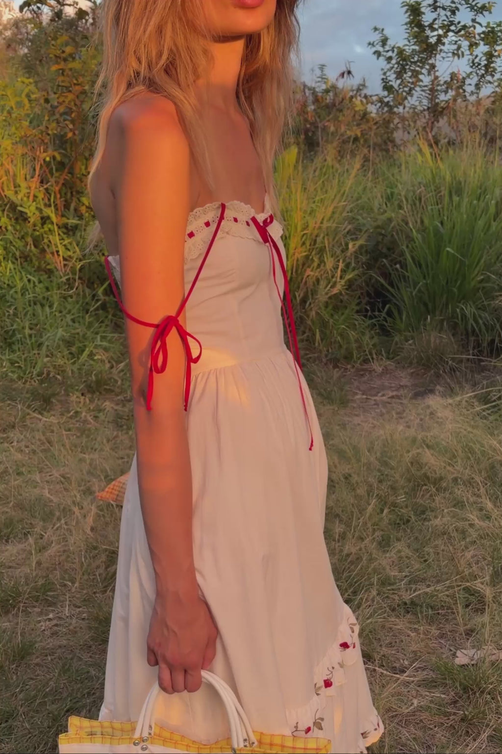 A close up video of a white dress with red accents