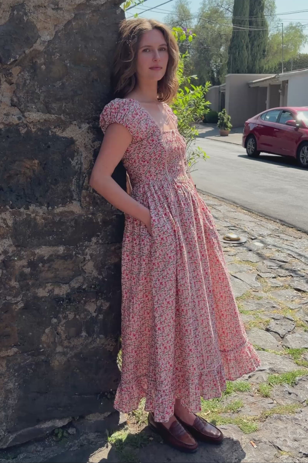 women in pink floral mushroom print dress walking down a city street on a warm sunny day